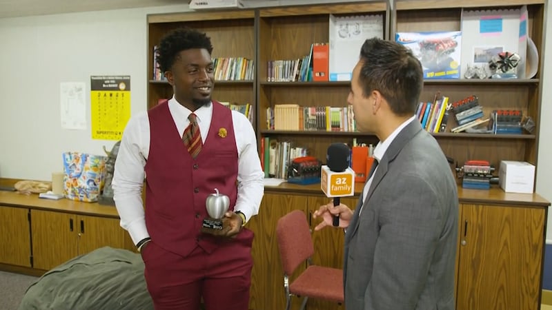 Colton Shone presents Superstition High School teacher Gary Mason with a Silver Apple award.