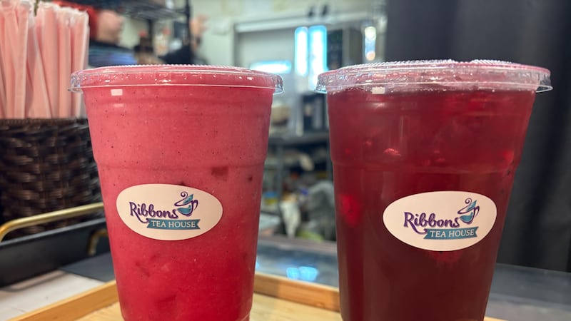 Two customs tea drinks including an iced raspberry hibiscus with dragon fruit pieces (right).